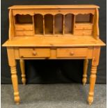 A 20th century pine writing desk, rectangular top above four small drawers and pigeonholes,