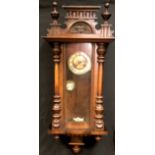 A walnut Vienna wall clock, enamelled chapter ring, Roman numerals, glazed door flanked by turned