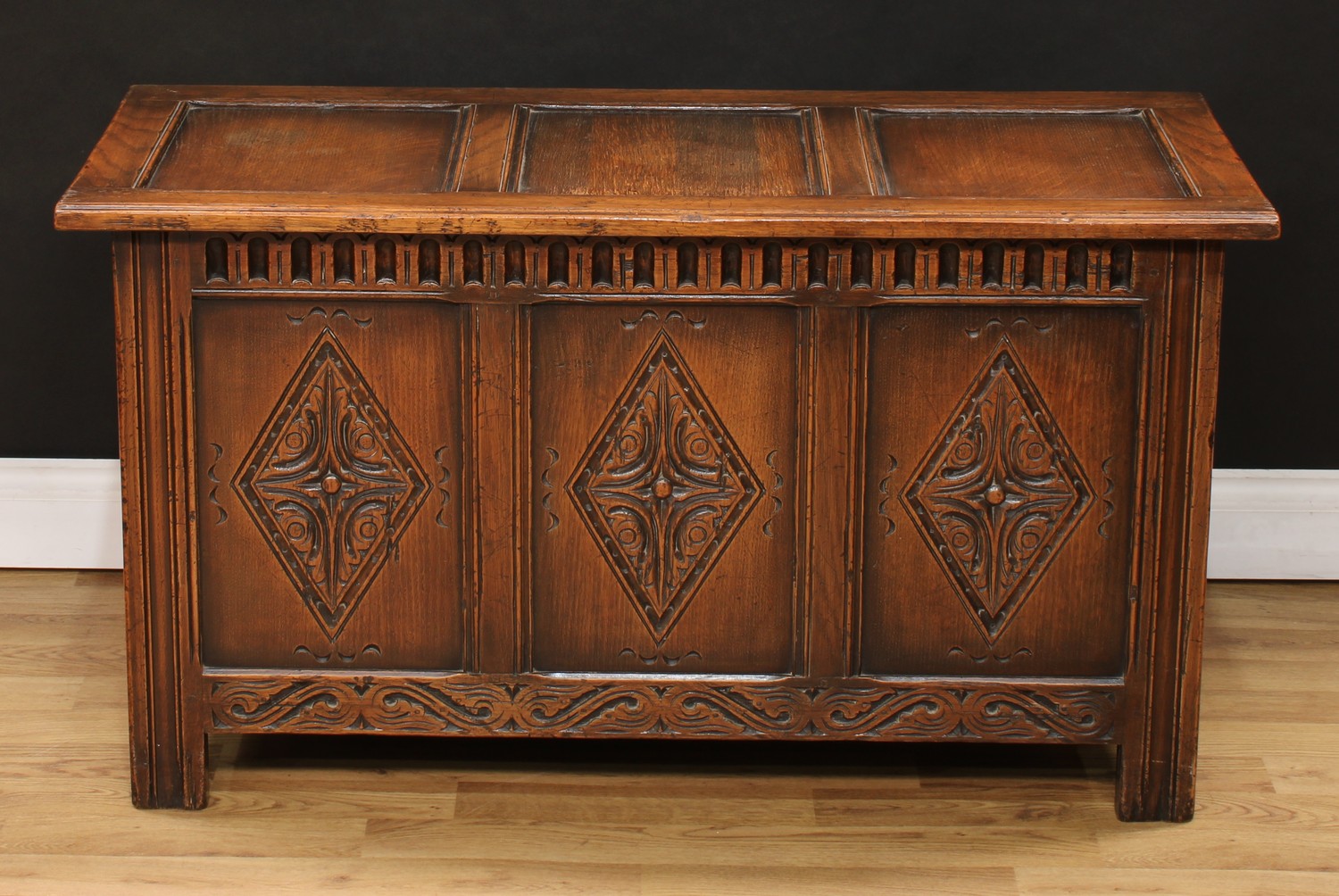 A 17th century style oak blanket chest, hinged top above a three panel front, nulled frieze, each