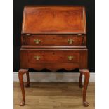 A George II Revival walnut bureau, fall front enclosing a small door, serpentine front drawers and