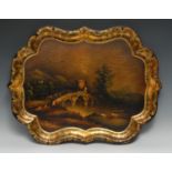 A Victorian papier mache shaped rectangular tray, painted with cattle beside a river bridge, gilt