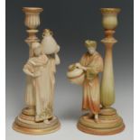 A matched pair of Royal Worcester figural candlesticks, The Cairo Water Carriers, in green,