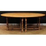 An oak wake table, oval top with fall leaves, turned supports, rectangular stretchers, 76.5cm