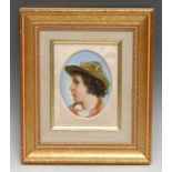 A German porcelain oval plaque, painted with the profile of a young peasant boy, in traditional