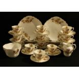 An Aynsley tea set for twelve, printed and painted with summer flowers, moulded with scrolls and
