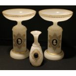 An opaque white glass garniture, comprising a pair of pedestal comports applied with cameo roundels,