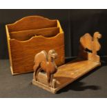 An early 20th century novelty bookslide, the end supports carved as camels; a pale oak desk top