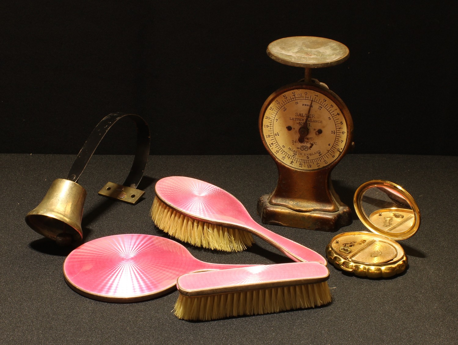 A silver engine turned pink enamel dressing table set, hand mirror and two brushes, Birmingham 1929;