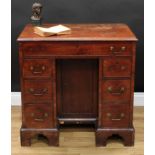 A George III mahogany kneehole desk, rectangular top with moulded edge above a long cockbeaded