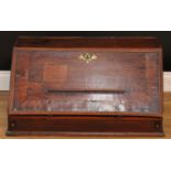 A George III oak table-top bureau, fall front with reading ledge enclosing a baize writing