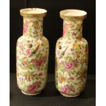 A pair of Chinese famille rose bottle vases; enamelled with pink blossom, birds and insects, 24cm,