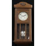 An oak chiming wall clock, Arabic numerals, twin winding holes, pendulum and key, 78cm