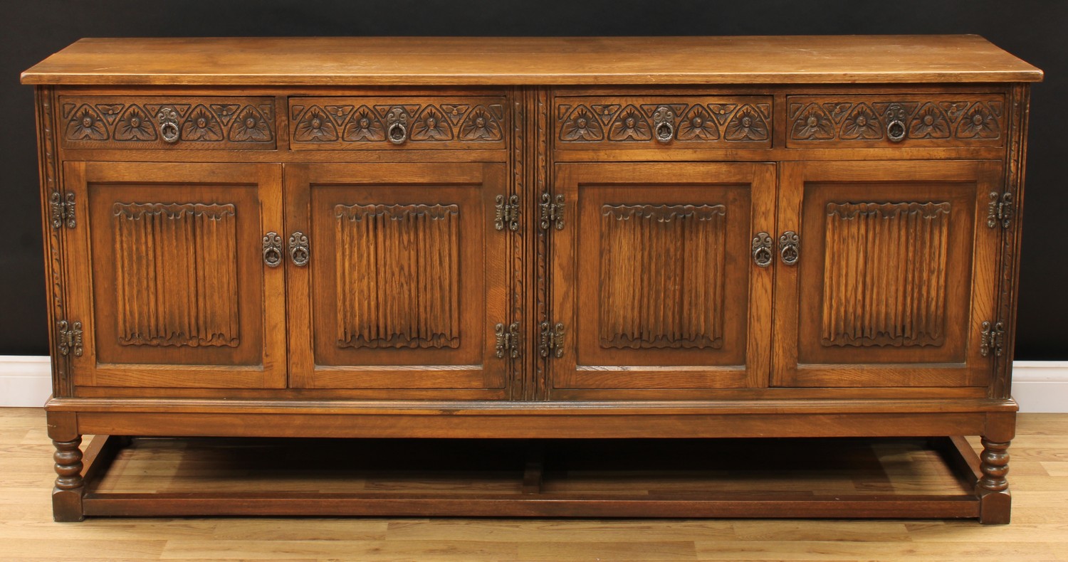 An Old Charm oak low dresser, rectangular top above four frieze drawers and two pairs of linenfold