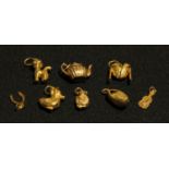 A selection of 9ct gold charms, teapot, clog, jacket, cat, duck, guitar, Koala, wishbone, marked