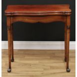 A George III Revival mahogany games table, hinged serpentine top enclosing four counter wells,