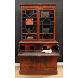 An early Victorian mahogany secretaire bookcase, oversailing cornice above a pair of glazed doors