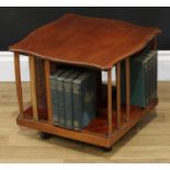 An Edwardian mahogany table top revolving bookcase, serpentine top novelty slatted divisions,