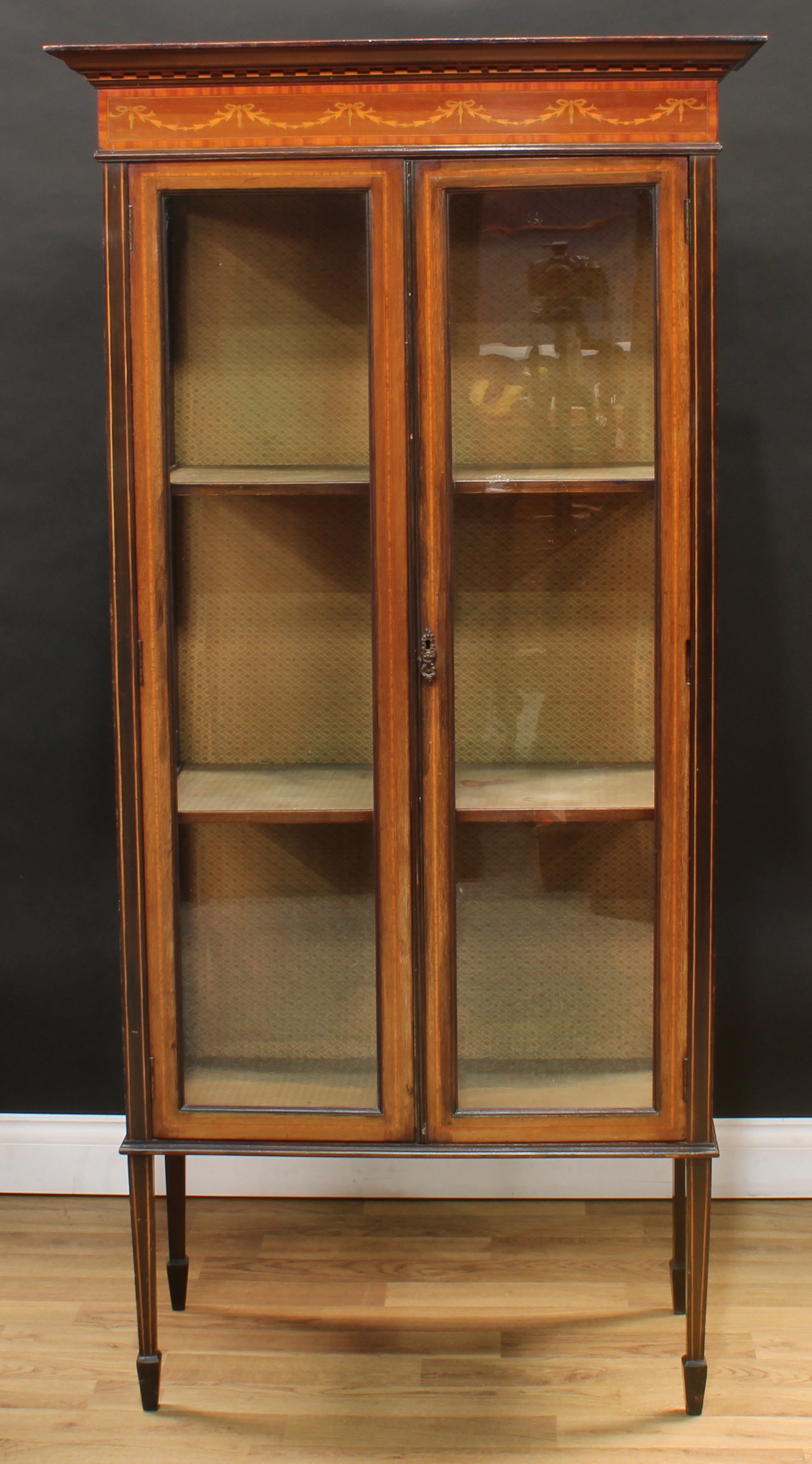 An Edwardian mahogany display cabinet, moulded cornice with shallow chequered parquetry apron