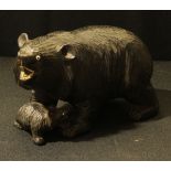 A Black Forest carving, as a bear and cub, glass eyes, 10.5cm tall.