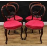 A set of four Victorian mahogany balloon back dining chairs, shaped mid-rails carved with stiff