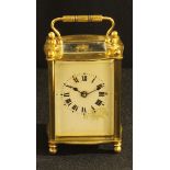 A French brass cased carriage clock, white enamel face, roman numerals, 11cm tall.