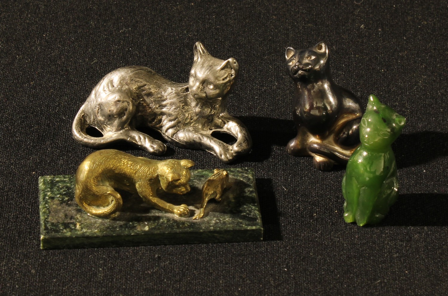 A Fininsh miniature brass model of a cat and mouse, 6cm wide; a jadeite miniature cat, 4cm; two