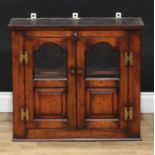 An oak wall hanging cabinet, shallow cornice above a pair of partially glazed doors, the lower