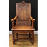 A 19th century oak Wainscot armchair, of pegged construction, shaped cresting rail centred by a