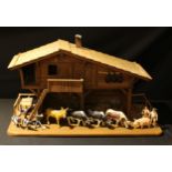 A chalet style doll's farmhouse, fitted with plastic figures, animals and accessories, 39cm x 67cm