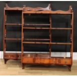 A near pair of mahogany wall shelves, each with three shaped serpentine front shelves above three