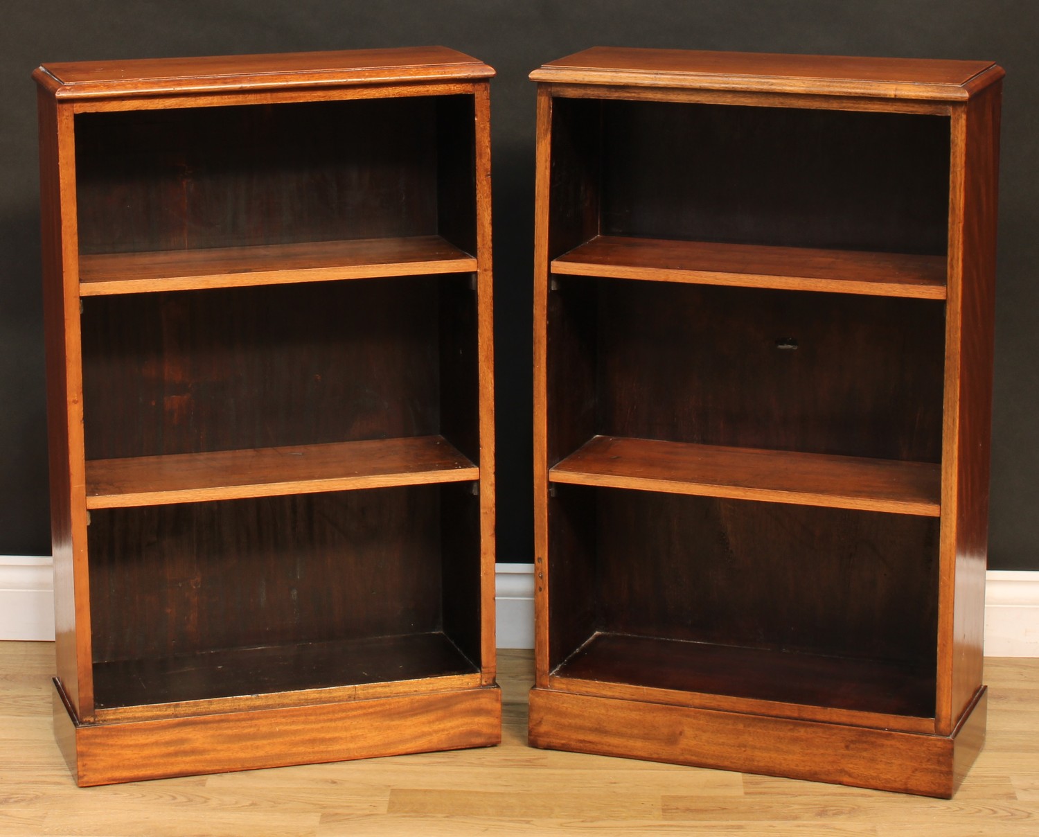 A pair of mahogany open bookcases, of small proportions, each with a moulded rectangular top above