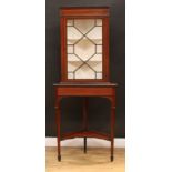 A George III Revival mahogany floor-standing corner display cabinet, moulded cornice above a faux-