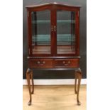 A contemporary George II style mahogany display cabinet, arch top above a pair of glazed doors