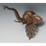 An early 20th century bronze novelty lamp bracket, cast as the head of an elephant, 23cm to tip of