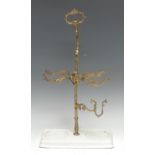 An unusual early 20th century gilt metal wine bottle stand/cradle, sprung mechanism, ceramic base,