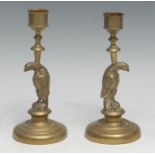 A pair of 19th century novelty candlesticks, each cast as a bird, circular bases, 16.5cm high, c.