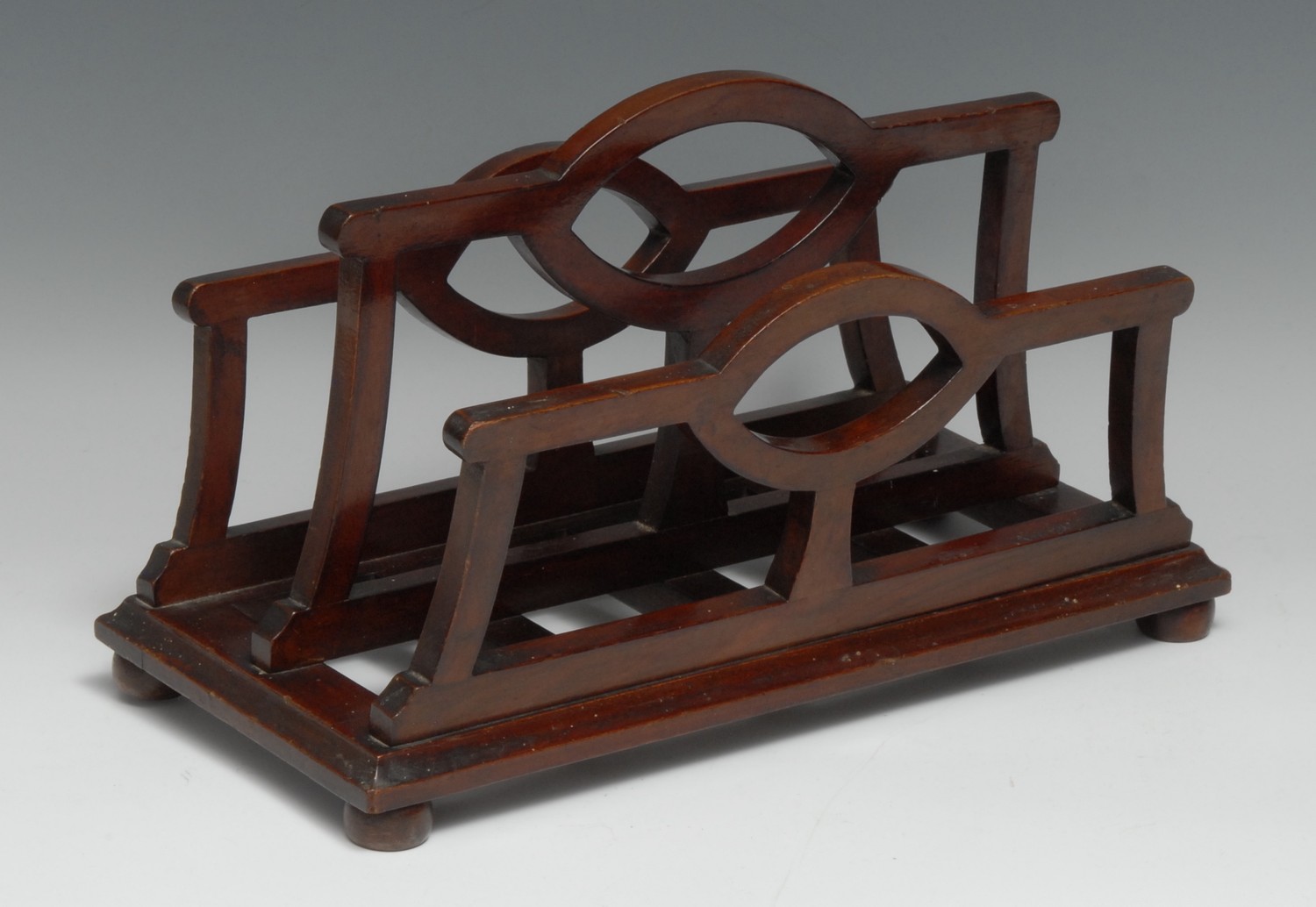 An unusual Edwardian mahogany table top canterbury stationery rack, shaped divisions, bun feet,