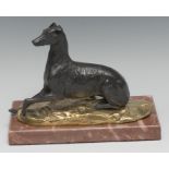 A 19th century dark patinated and parcel gilt desk bronze, of a dog, poised, alert, rectangular