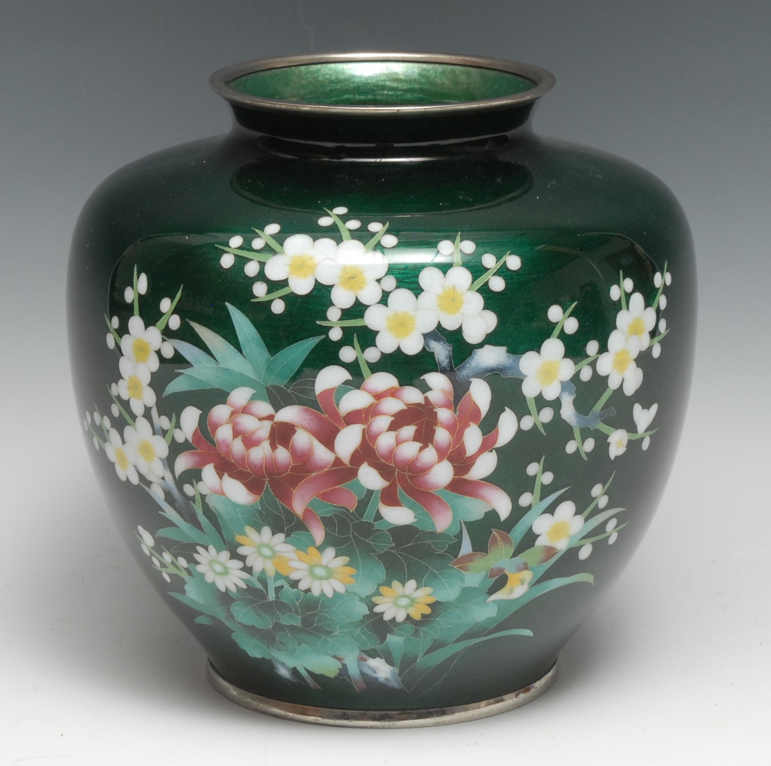 A Japanese cloisonne ovoid vase, decorated with chrysanthemums and blossoming prunus, on a green