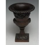 Treen - a 19th century oak half-fluted campana mantel urn, carved and applied with masks and