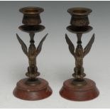 A pair of 19th century Egyptian Revival gilt bronze candlesticks, each cast as a seated sphinx,