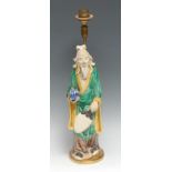 A Chinese figure, of an elder holding a peach, glazed in mottled tones of green, yellow, and blue,