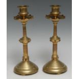 A pair of Victorian Gothic Revival gilt brass candlesticks, in the Burges taste, columnar sconces