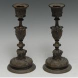 A pair of 19th century Renaissance Revival bronze candlesticks, cast with figures, masks and