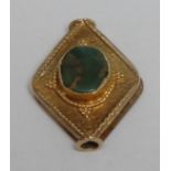 Antiquities - a Near Eastern yellow metal canted lozenge-shaped pendant, possibly gold, cast in