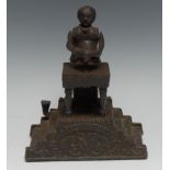 A decorative cast iron novelty money box, the Magician bank, 19cm high, 20th century