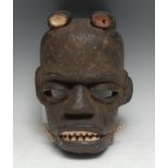 Tribal Art - a West African mask, articulated jaw with bared teeth, picked out in red and white