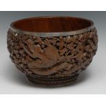 A Burmese silver coloured metal mounted hardwood bowl, boldly carved with dragons amongst dense