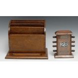 An early 20th century oak perpetual desk calendar, sarcophagus cresting above glazed apertures