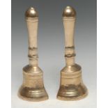 A pair of brass book ends or door stops, cast as a bisected bell, 23cm high